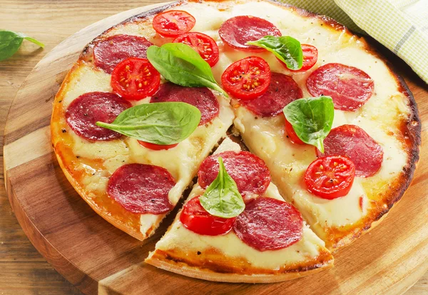 Pizza geserveerd op houten tafel. — Stockfoto