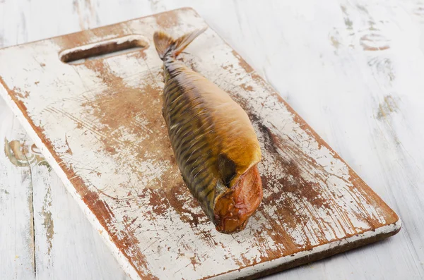 Peixe fumado numa tábua de madeira branca velha . — Fotografia de Stock