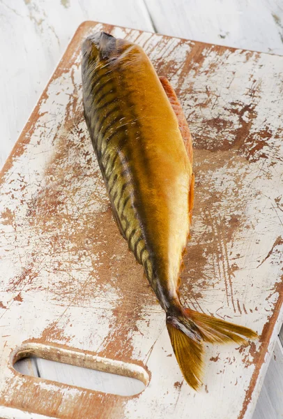 Pesce affumicato su tavola di legno bianca . — Foto Stock