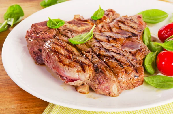 T-bone steak with green salad and tomatoes — Stock Photo, Image