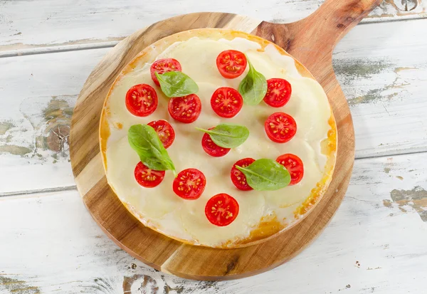 İtalyan Pizza domates ahşap bir masa üzerinde. — Stok fotoğraf