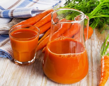 Glass of carrot juice and fresh carrots clipart