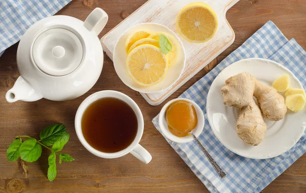 Teekanne und Tasse Tee mit Zitrone, Ingwer und Minze — Stockfoto