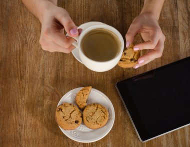 Tablet bilgisayar ve kahve fincanı ile kadın el. 