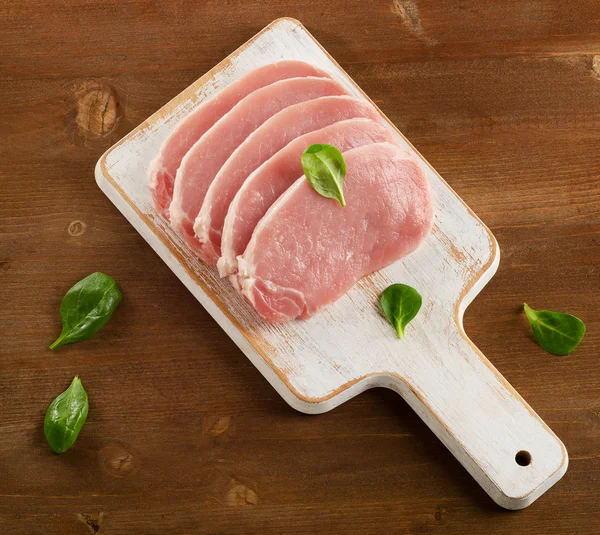 Raw pork on a wooden cutting board. — Stock Photo, Image