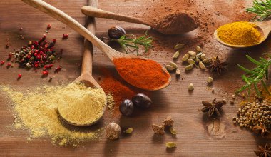 Ahşap masada çeşitli renkli baharatlar var.