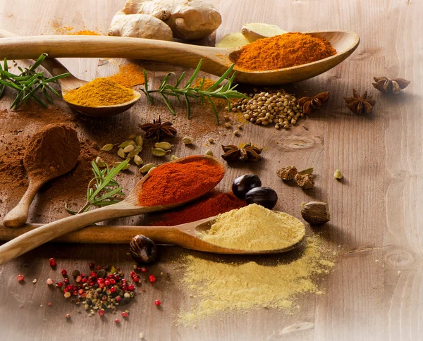 Various colorful spices on a wooden table — Stock Photo, Image