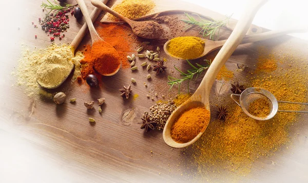Various spices and herbs on a wooden board — Stock Photo, Image
