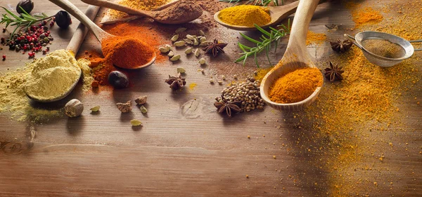 Various spices and herbs on wooden board — Stock Photo, Image