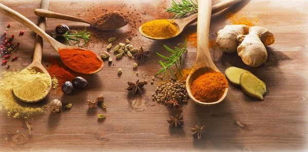 Spices and herbs on a wooden background — Stock Photo, Image