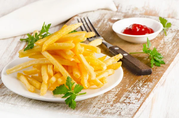 French fries on a wooden board — Stock Photo, Image