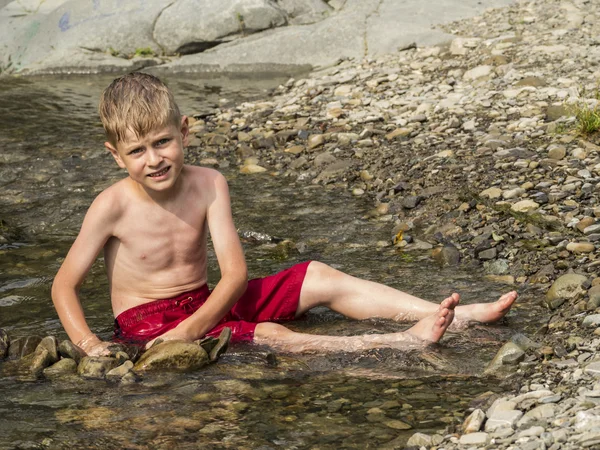 Pojke bygger en dam — Stockfoto