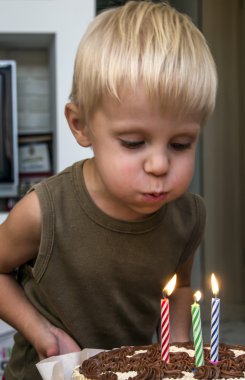 üç yaşında bir çocuk onun doğum günü kutluyor