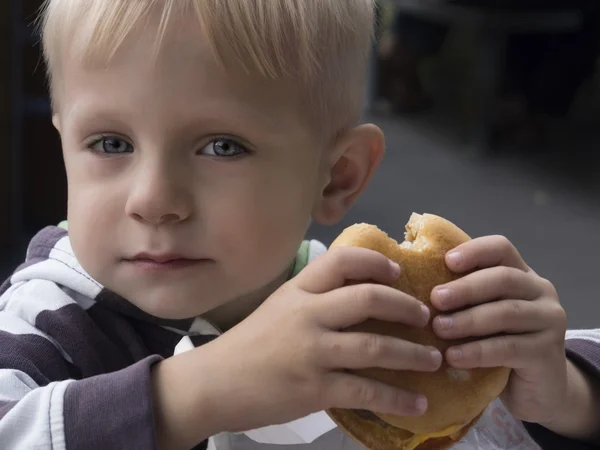 Niño comiendo hamburguesa — Foto de Stock