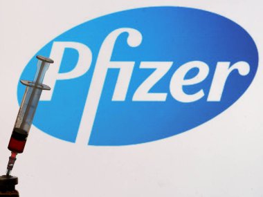 Kiev, Ukrayna, 18 Kasım 2020. Editör çizimi. Bu fotoilüstratn tıbbi şırıngada Pfizer şirketinin logosu arka planda bir ekranda gösteriliyor. 