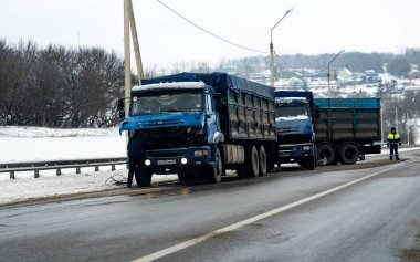 KURSK, RUSSA - 15 Ocak 2021: Küçük bir kazaya yol açan buzlu bir yolda bir trafik polisi güvenliği denetliyor. Kursk 'taki kamu hizmetleri kar temizliği ile başa çıkamıyor.