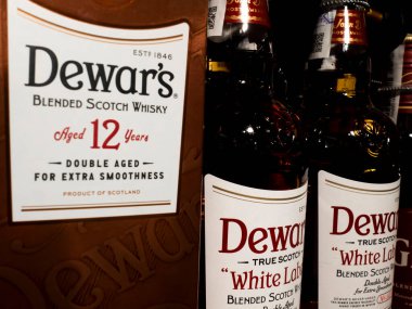 Dewar 'ın Beyaz Etiketi' nin manzarası Süpermarketin rafında gerçek viski şişeleri