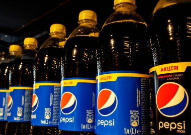 Süpermarketin rafındaki şişedeki Pepsi içeceklerini kapat. Pepsi, PepsiCo tarafından üretilen ve üretilen bir alkolsüz içecek..
