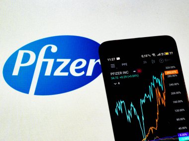 KIEV, UKRAINE - 13 Şubat 2021: Bu resimde Pfizer, Inc. 'nin borsa bilgileri akıllı telefonda sergilenirken, Pfizer, Inc. logosu arka plan olarak gösteriliyor