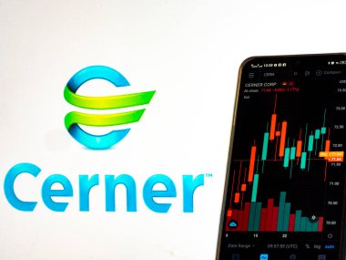 Kiev, Ukrayna, 31 Mart 2021. Bu resimde Cerner Şirketi 'nin borsa bilgileri arka planda Cerner Şirketi logosu olan bir akıllı telefonda sergileniyor..