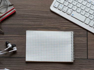 Masadaki bilgisayar klavyesi ve not defterinin yüksek açılı görünümü