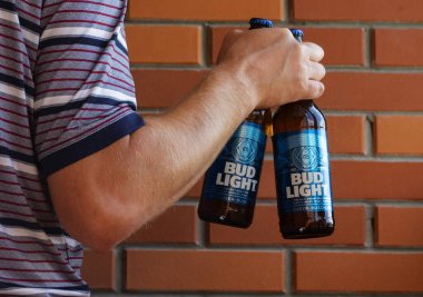 Kiev, Ukrayna, 28 Ağustos 2021. Bu resimde, adam arka planda Bud Light bira şişelerini tutuyor. Bu bira Anheuser-Busch tarafından üretiliyor, mürekkep..