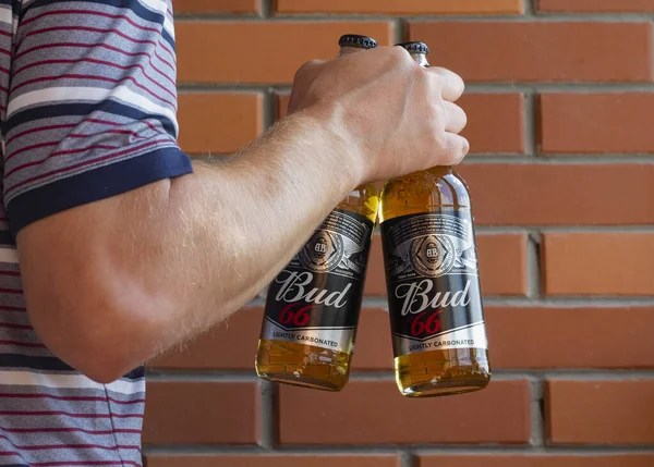 キエフ ウクライナ 2021年8月28日 この写真のイラストでは 男は醸造所の壁の背景にバド66ビールボトルを保持しています このビールはAnheuser Busch Inkが製造している — ストック写真
