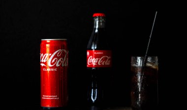 Kiev, Ukrayna, 3 Eylül 2021. Siyah arka planda kutu kutu ve bir şişe Coca Cola.