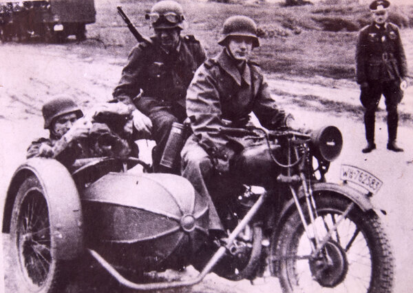 German soldiers riding in a motorcycle with sidecar