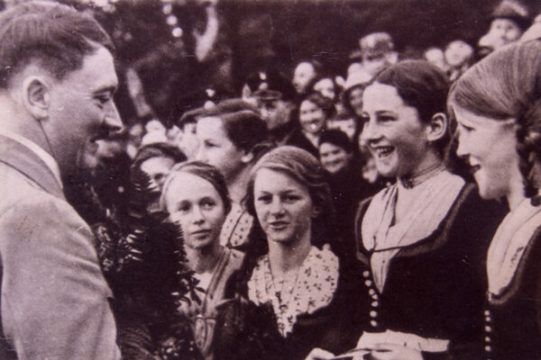 Adolf Hitler talking to young girls during a meeting