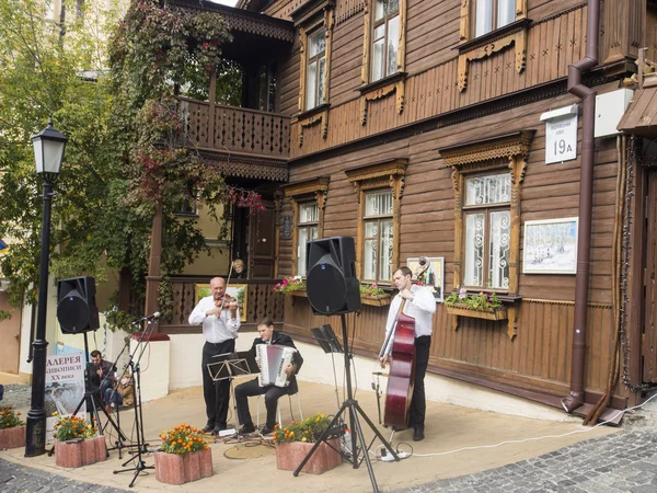 Musicians perform in front of wooden house — Stock Photo, Image