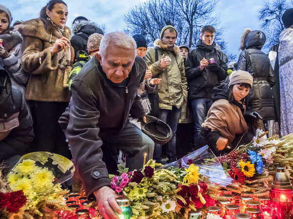 Ukrainians lay lamps and bunches of flowers