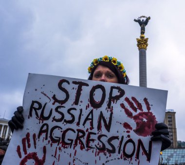 25 JANUARY, 2015 -- KYIV, UKRAINE: Indifferent Ukrainian holds a placard against Russian aggression.
