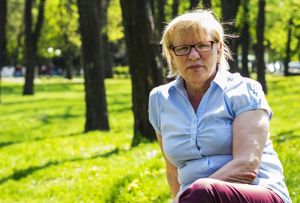 Orta yaşlı bir kadın parkta — Stok fotoğraf