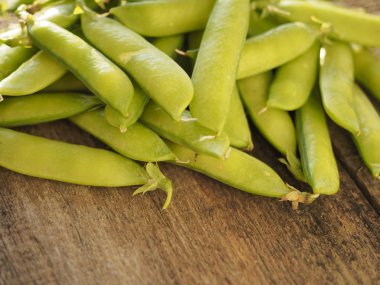 green peas on a rustic wooden board