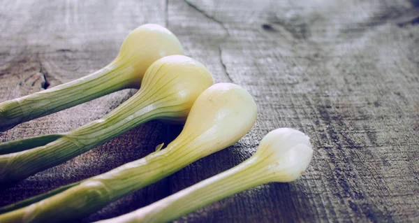 Green onions on a weathering wood background — Stock Photo, Image