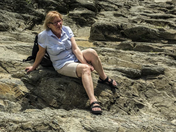 Woman sitting on rocks — Stock Photo, Image