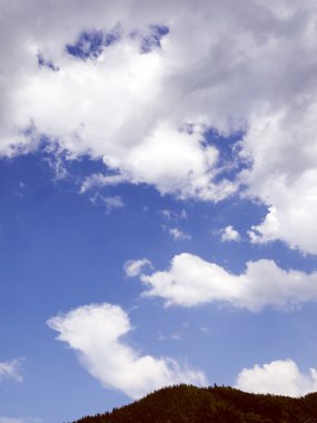 Mavi Gökyüzü bulutlu Dağları altında. 