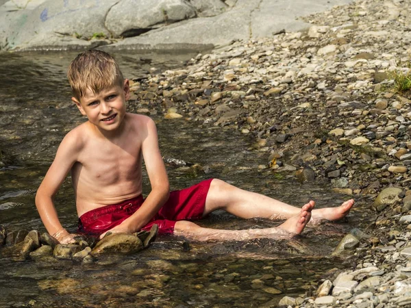 Kleiner kaukasischer Junge in roten Shorts — Stockfoto