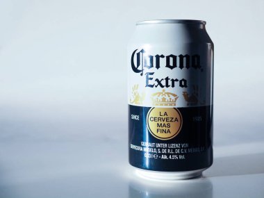 Almanya - 3 Mart 2026: Dramatik gölgeler ve temiz arkaplan ile beyaz ve altın renkli bir Corona Extra bira kutusu.