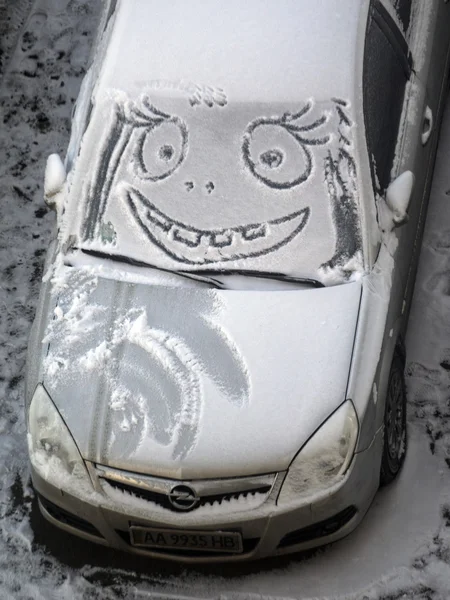 Funny face on snow covered car — Stock Photo, Image