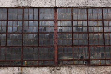 Eski fabrika pencereleri, paslı metal ve eski beton.