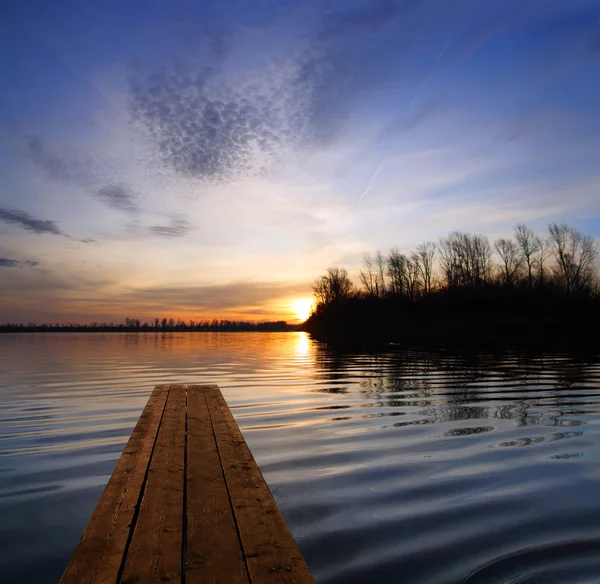 River landscape with pier and sunset on river — Stock Photo, Image