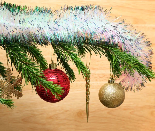 Christmas toys on fir tree twig and wood background — Stock Photo, Image