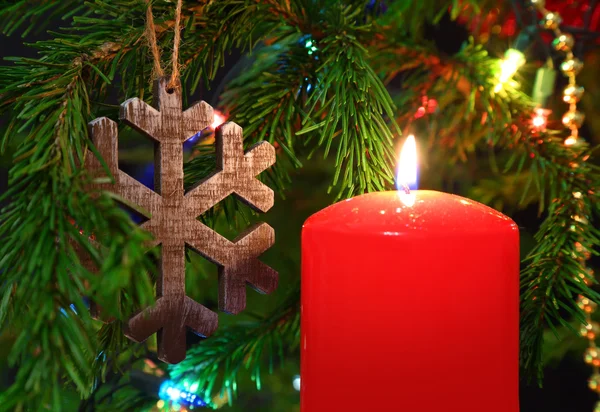 Weihnachten - Kerze und hölzerne Schneeflocke auf Tanne — Stockfoto