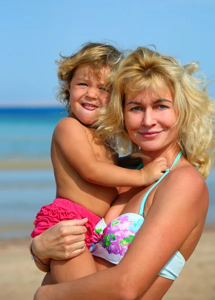 Szczęśliwa matka z dzieckiem na plaży — Zdjęcie stockowe