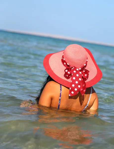 Frau mit Hut am Strand — Stockfoto