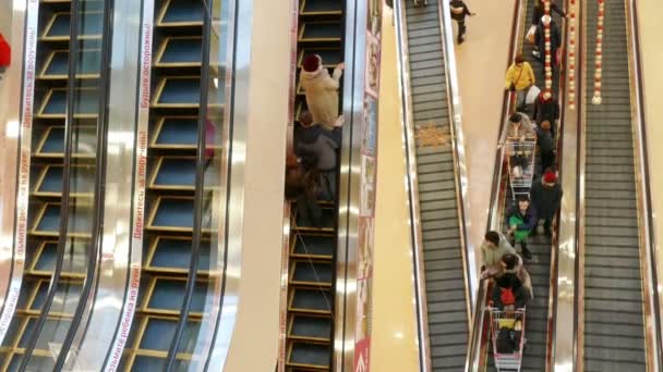 Pessoas em movimento em escadas rolantes no shopping center moderno — Vídeo de Stock