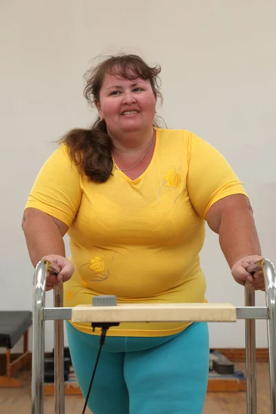 Overweight woman running on trainer treadmill — Stock Photo, Image