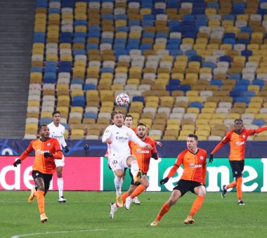 KYIV, UKRAINE - 1 Aralık 2020: Shakhtar Donetsk (in Orange) ve Real Madrid (in White) oyuncuları NSC Olimpiyskyi stadyumunda oynanan UEFA Şampiyonlar Ligi maçında bir top için mücadele ederler. Shakhtar 2-0 kazandı.